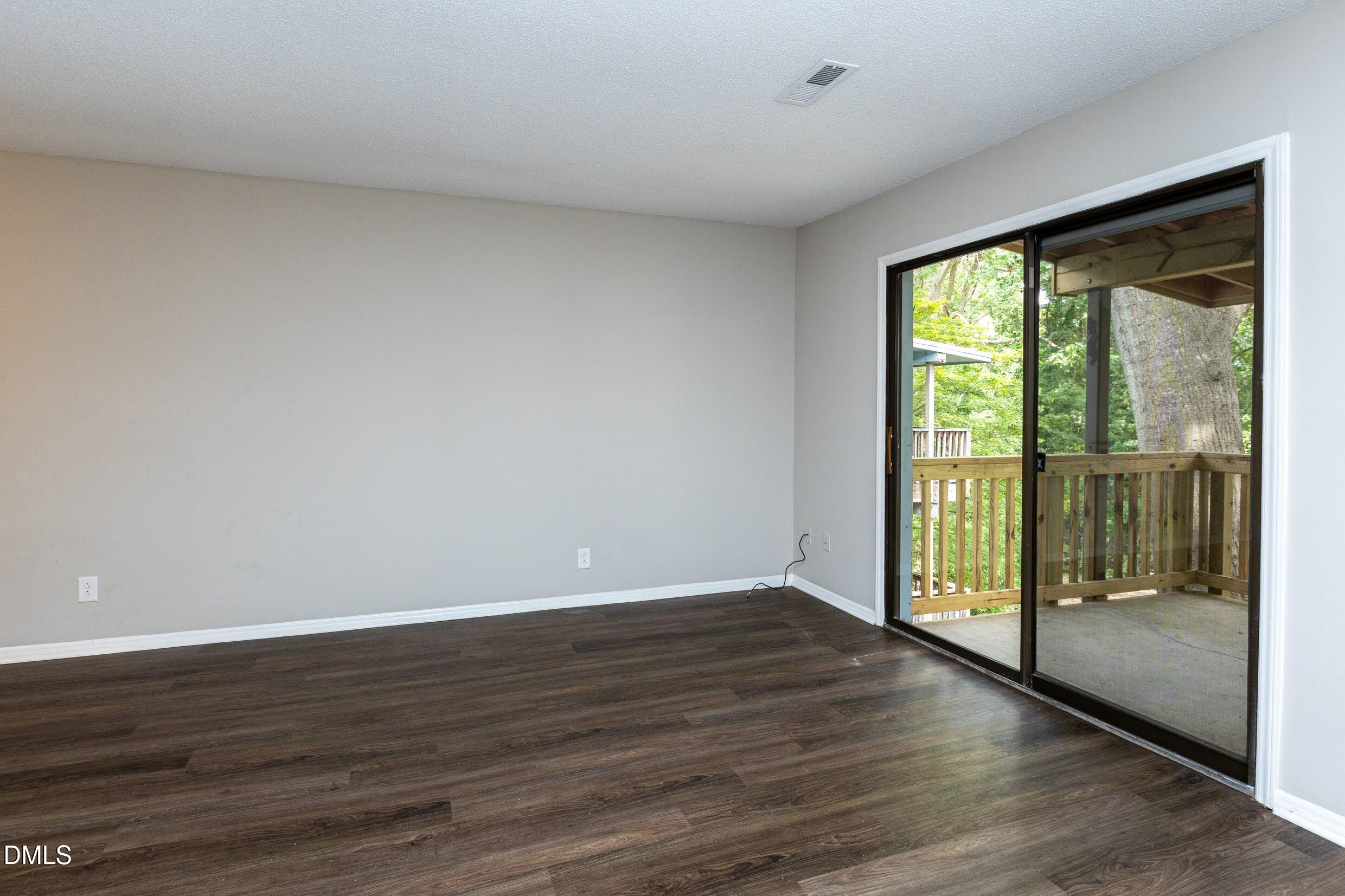 5036 Flint Ridge Place Raleigh, NC 27609 - Photo 6 of 21 a view of an empty room with wooden floor and a window