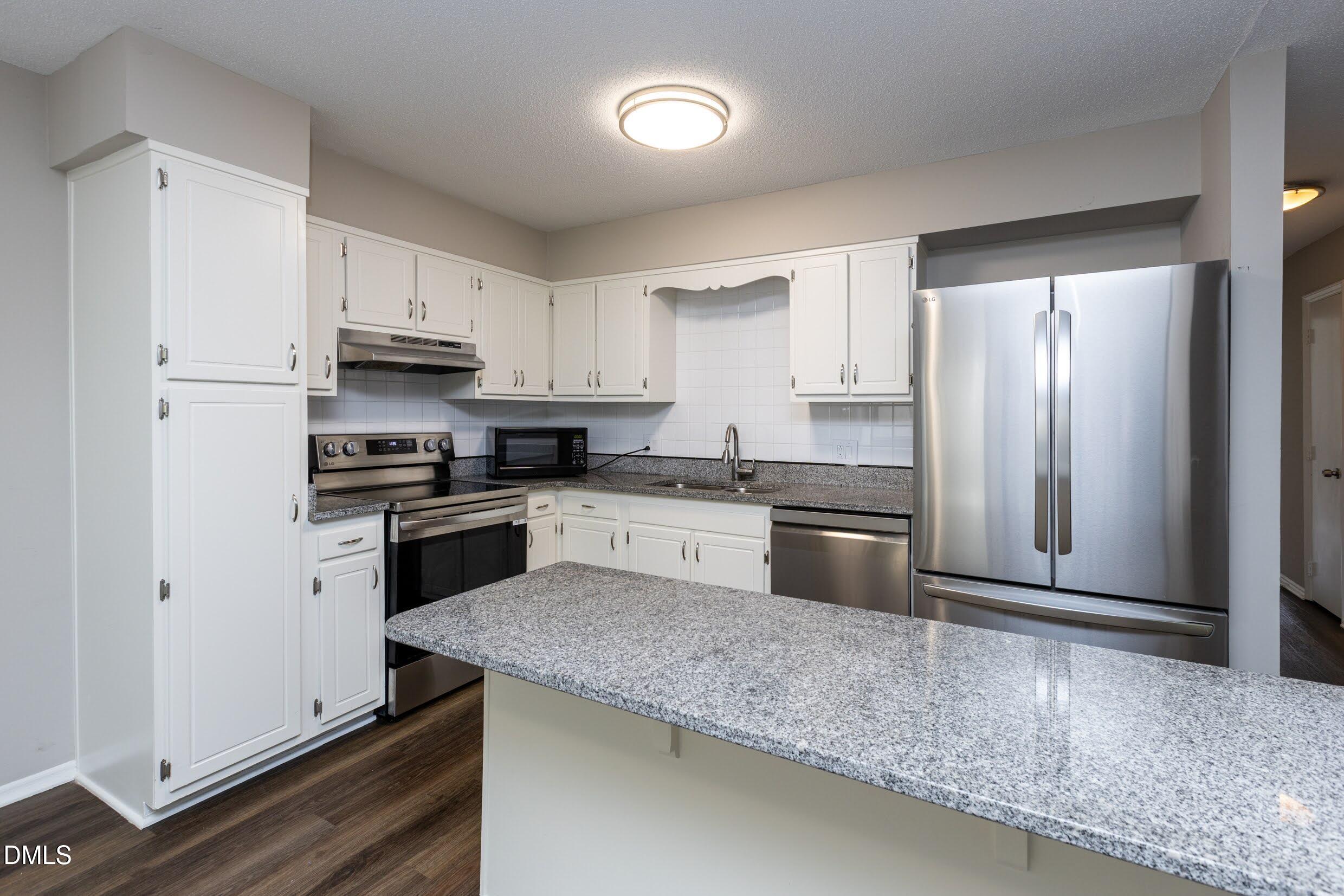5036 Flint Ridge Place Raleigh, NC 27609 - Photo 10 of 21 a kitchen with granite countertop a refrigerator sink and stove