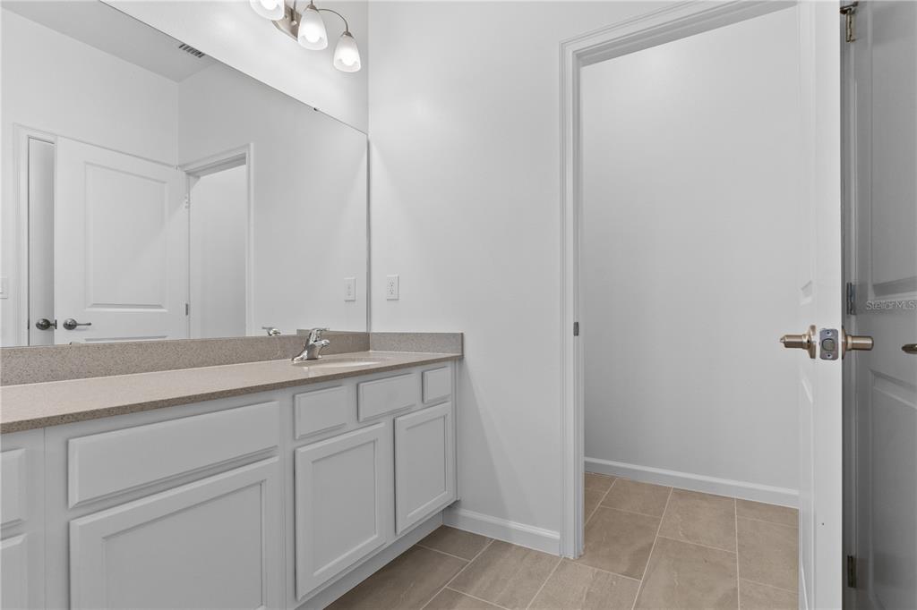 1205 Butterfly Orchid Road Davenport, FL 33837 - Photo 31 of 69 a bathroom with a double vanity sink and mirror