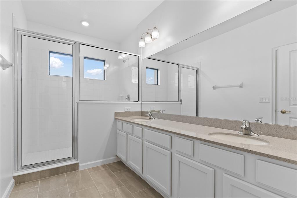 1205 Butterfly Orchid Road Davenport, FL 33837 - Photo 36 of 69 a bathroom with a double vanity sink and mirror