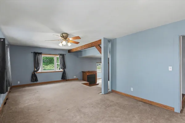 a view of a room with a ceiling fan and window