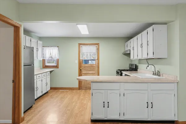 a kitchen with sink cabinets and wooden floor