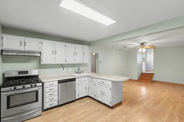 a kitchen with granite countertop a sink cabinets and stainless steel appliances
