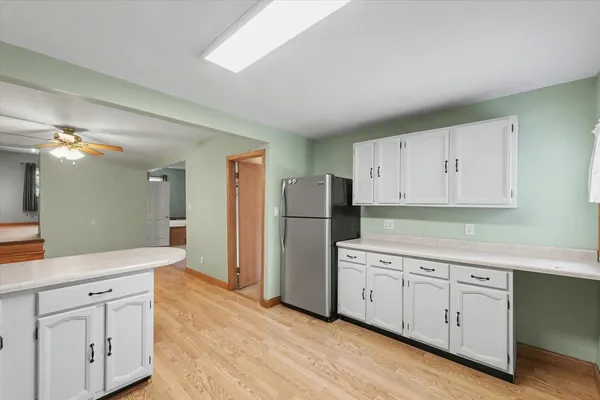 a kitchen with white cabinets and refrigerator