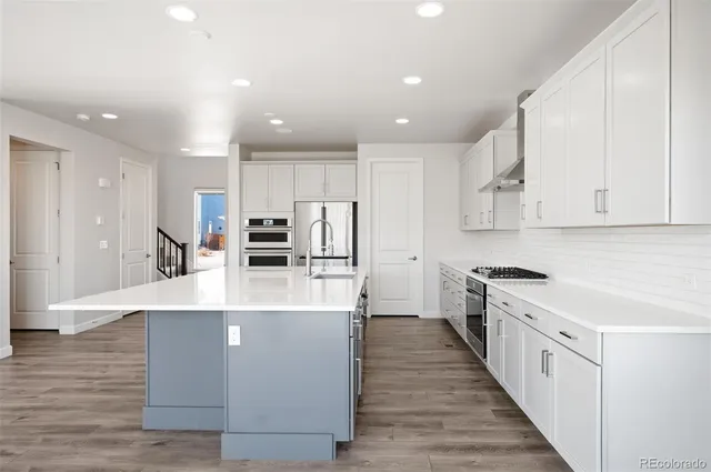 a large kitchen with stainless steel appliances and a large counter top
