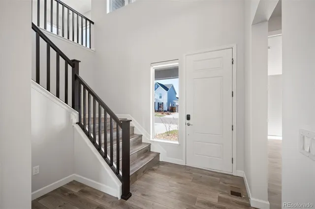 a view of a hallway with wooden floor and staircase