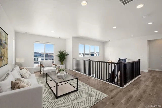 a view of a big room with wooden floor and windows