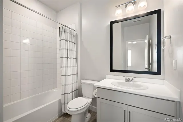 an empty room with ceiling fan and window