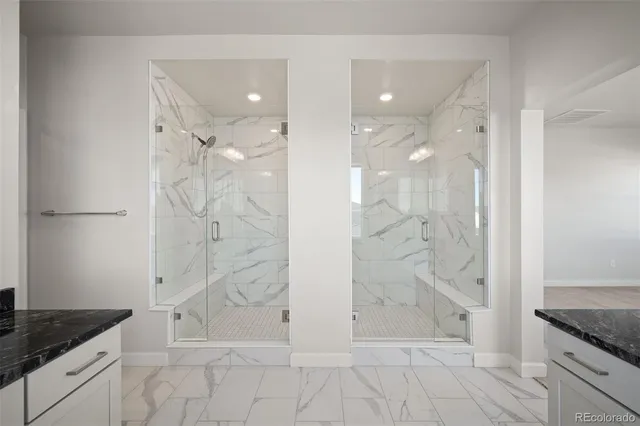 a bathroom with a granite countertop sink a shower and mirror