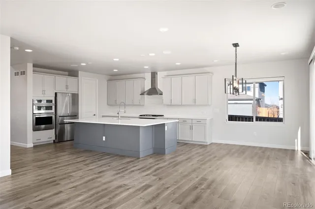 a large kitchen with kitchen island a sink stainless steel appliances and cabinets