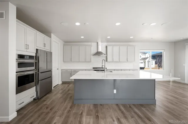 a large kitchen with kitchen island a large counter top space a sink stainless steel appliances and cabinets