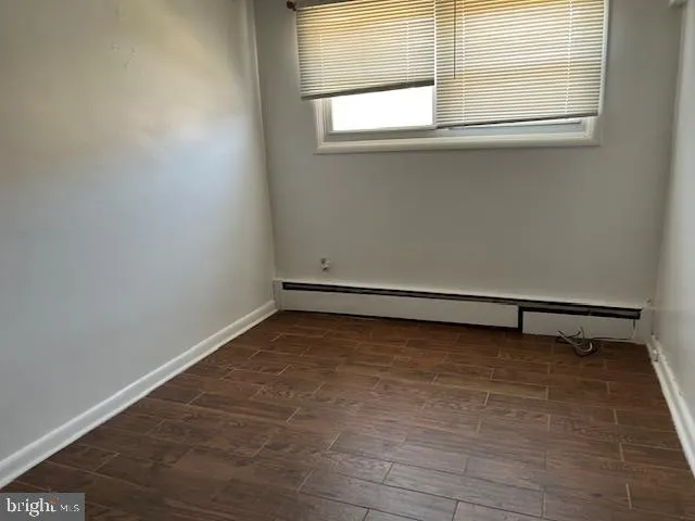 a view of a small space with wooden floor and a window