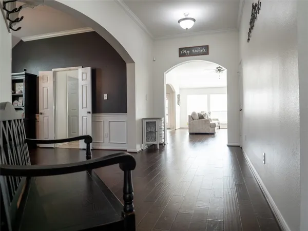 a view of a hallway with wooden floor and furniture