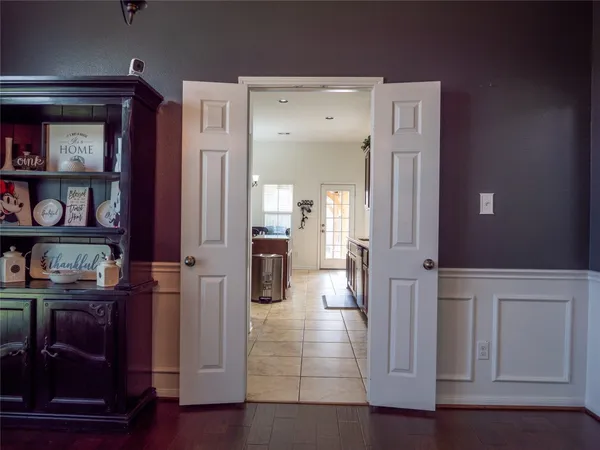 a view of a hallway with wooden floor and cabinet