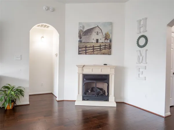 an empty room with a fireplace and wooden floor