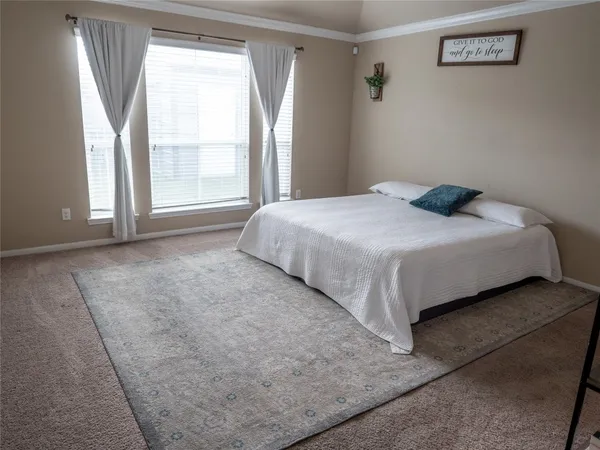 a large bed sitting in a bedroom next to a window