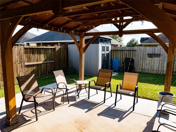 a view of chair and tables in the patio next to a yard