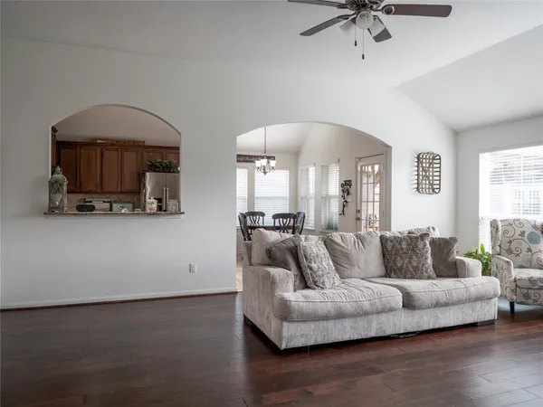 a living room with furniture and a wooden floor