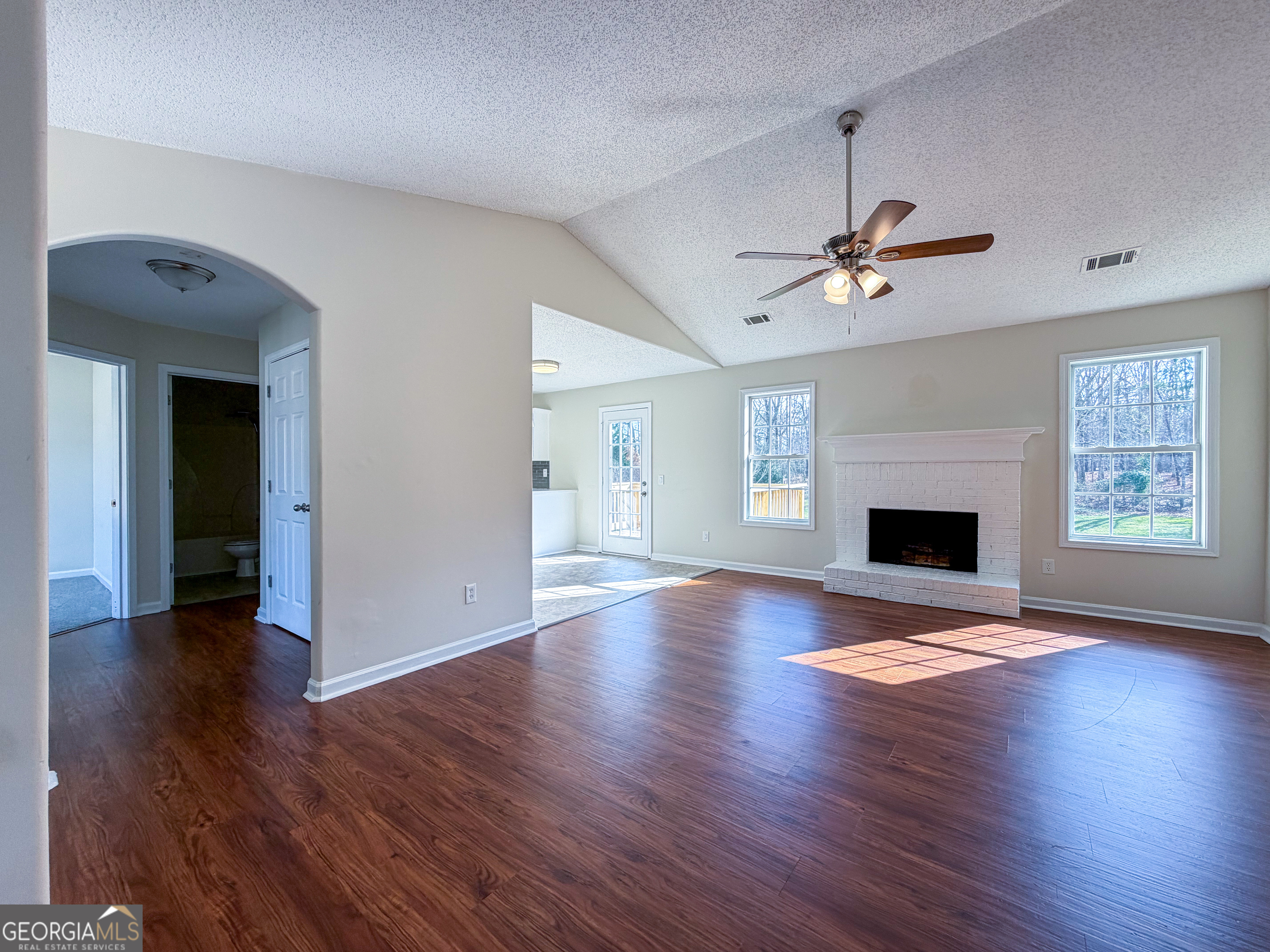 1119 Hummingbird Way Winder, GA 30680 - Photo 7 of 38 a view of an empty room with wooden floor fireplace and a window