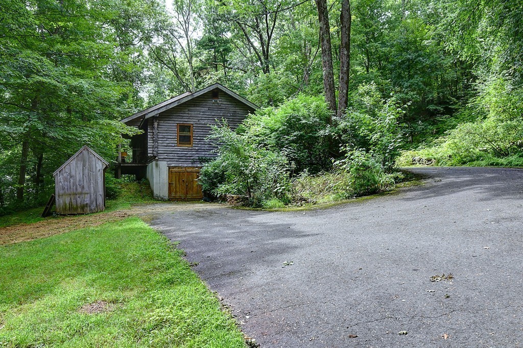 65 Allen Hill Road Holland, MA 01521 - Photo 1 of 29 a backyard of a house with plants and large tree
