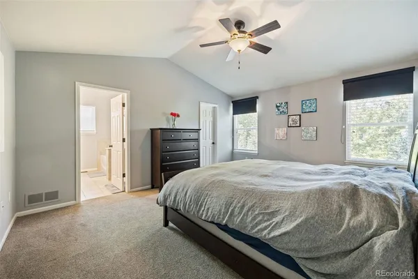 a bedroom with a large bed a chandelier and dresser