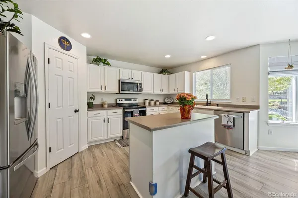 a kitchen with white cabinets and stainless steel appliances
