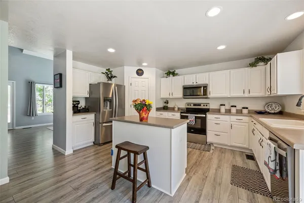 a kitchen with white cabinets and stainless steel appliances