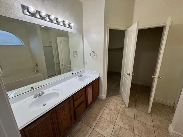 a spacious bathroom with a bathtub sink and mirror
