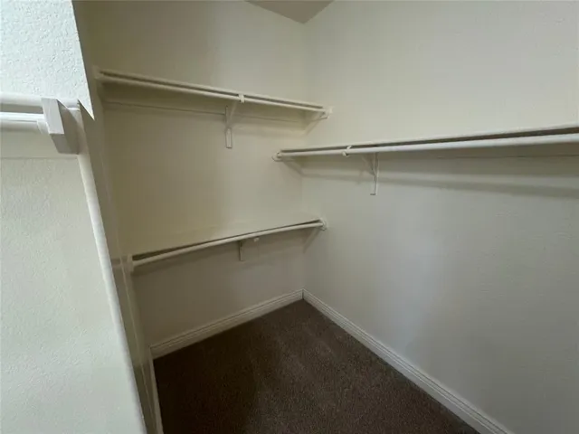 a view of walk in closet with empty racks