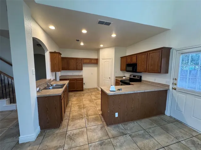 a kitchen with a sink a refrigerator and cabinets