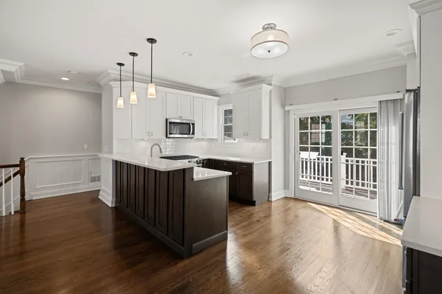 a kitchen with stainless steel appliances granite countertop a stove a sink dishwasher a refrigerator and a oven with wooden floor