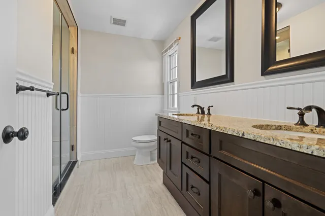 a spacious bathroom with a granite countertop sink toilet and shower