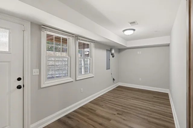 a view of empty room with wooden floor and fireplace