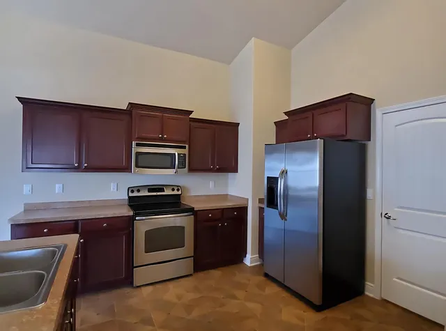 a kitchen with stainless steel appliances granite countertop a refrigerator stove and microwave