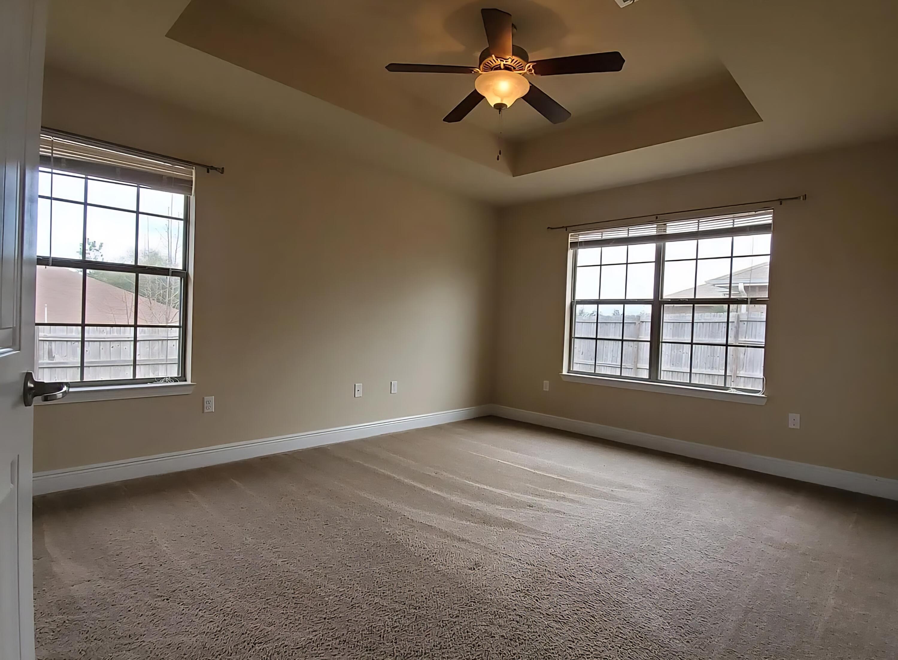 110 Bronze Circle Crestview, FL 32539 - Photo 7 of 12 an empty room with chandelier fan and windows