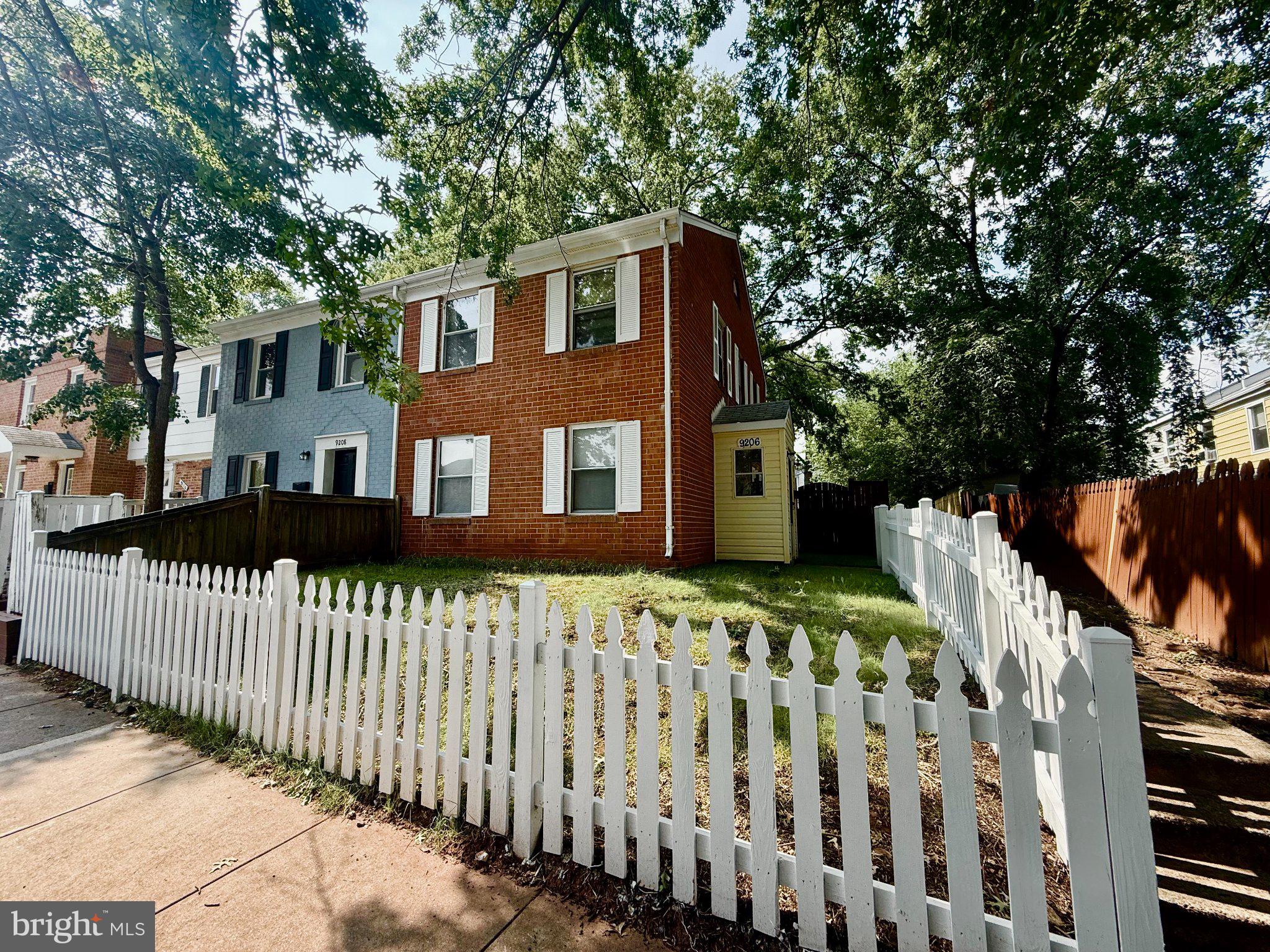 Charming brick home with white picket fence.