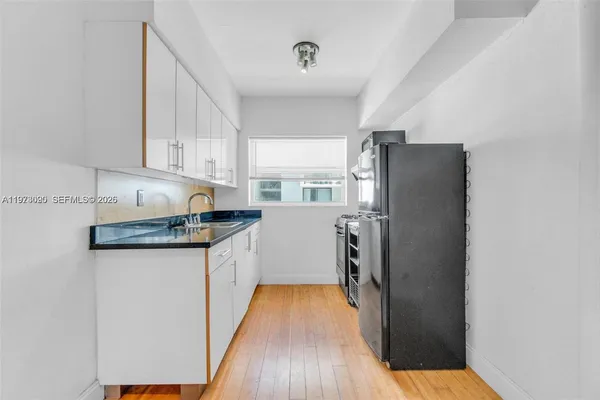 a kitchen with granite countertop a refrigerator and a sink
