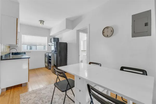a kitchen with stainless steel appliances refrigerator dining table and chairs