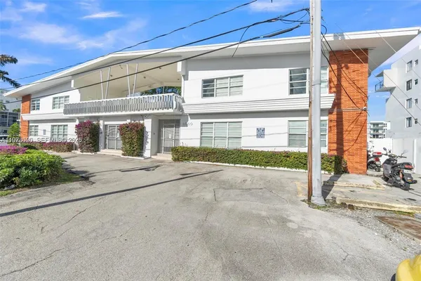 a front view of a building with a garden and plants