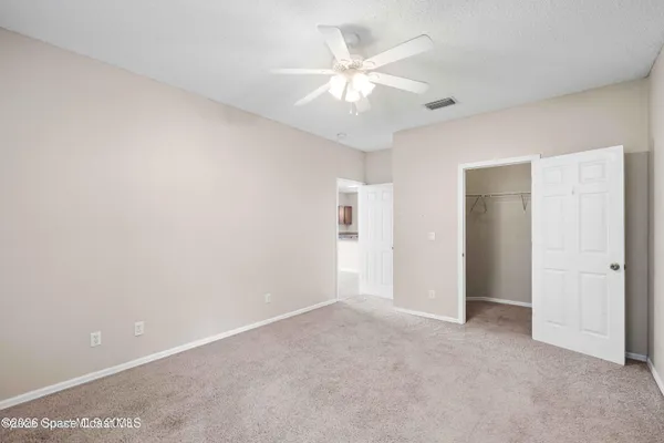 an empty room with a ceiling fan and a bathroom
