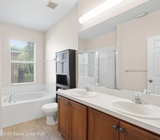 a bathroom with a sink toilet double vanity and bathtub
