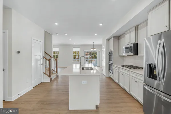a kitchen with stainless steel appliances a refrigerator sink and microwave