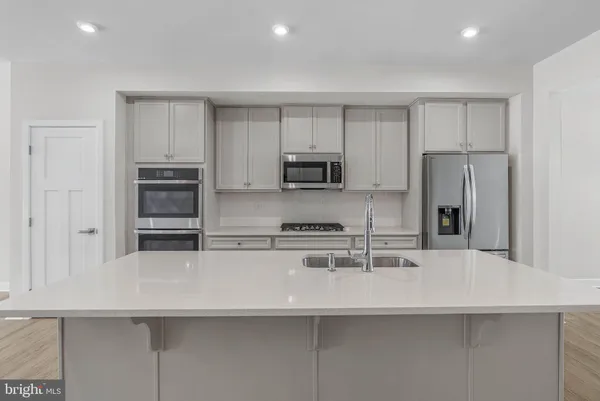a kitchen with granite countertop a sink stainless steel appliances and cabinets