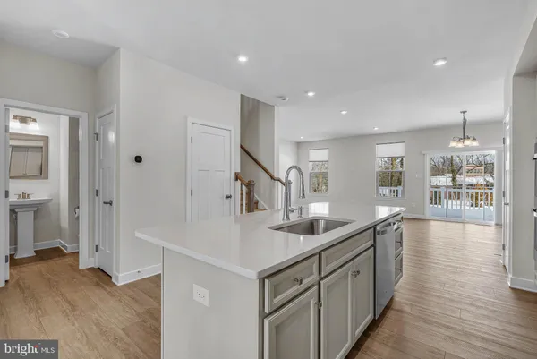 a large white kitchen with a stove top oven a refrigerator and cabinets