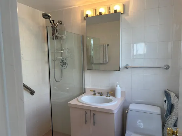 a bathroom with a toilet sink shower and mirror