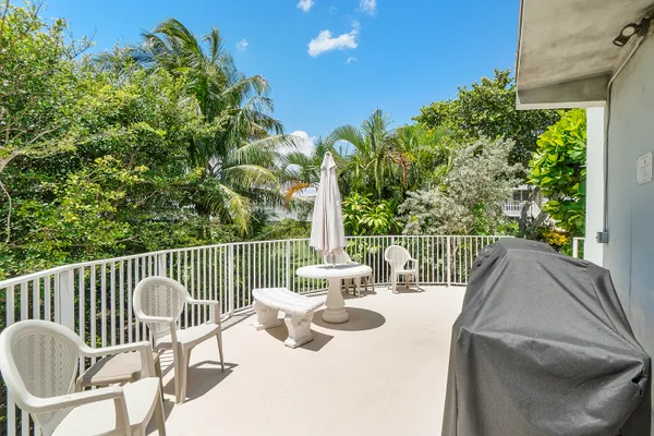 a view of a chair and tables in the balcony