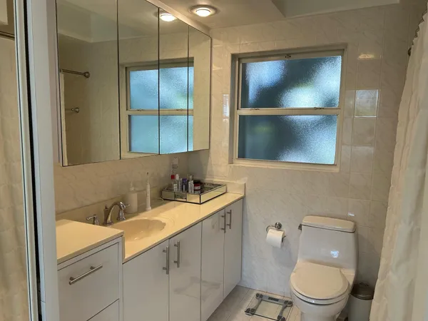 a bathroom with a toilet sink and mirror