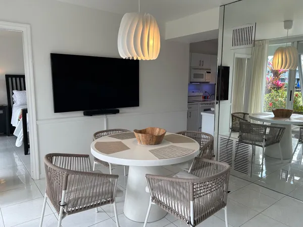 a living room with furniture a flat screen tv and kitchen view