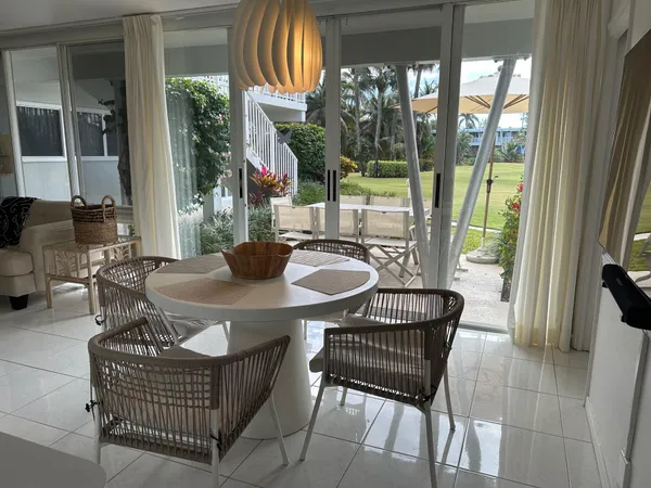 a dining room with furniture and a floor to ceiling window