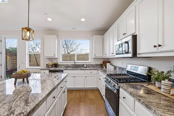 a kitchen with stainless steel appliances granite countertop a stove and a sink